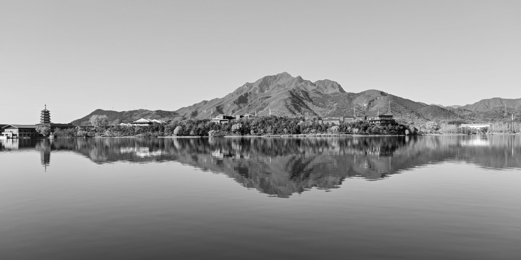 Calm lake with mountain and shoreline reflected symmetrically in the water.