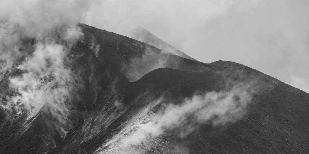 Etna ridge partly covered by drifting cloud or smoke.