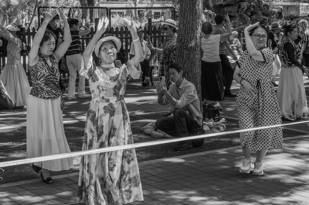 Group of women dancing in a public park.