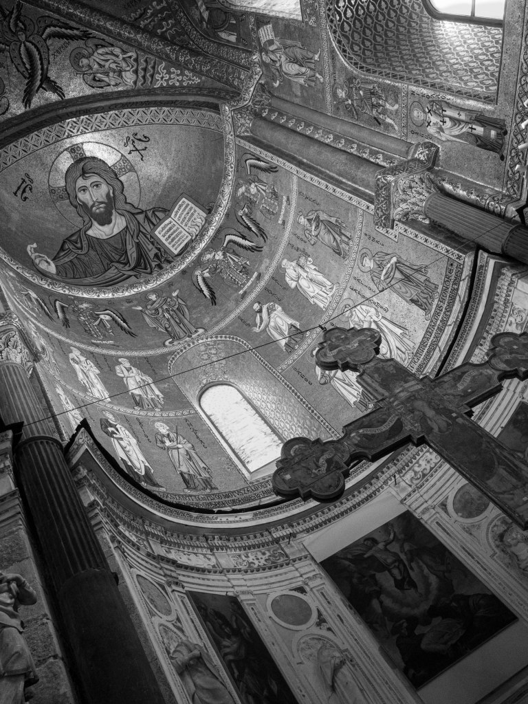 An angled interior view shows the mosaic of Christ and the richly decorated apse of Cefalù Cathedral.